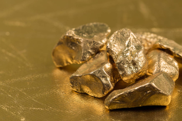 Gold nuggets on a gold background - Foto, Imagen