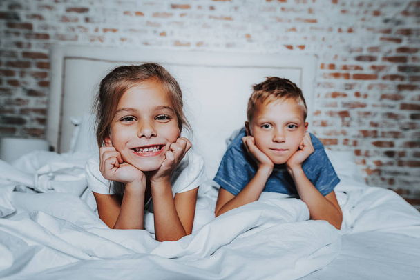 Little boy and girl laying on bed together - Photo, image