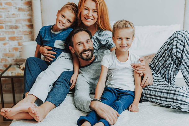 Happy parents and two kids together in bed - Fotoğraf, Görsel