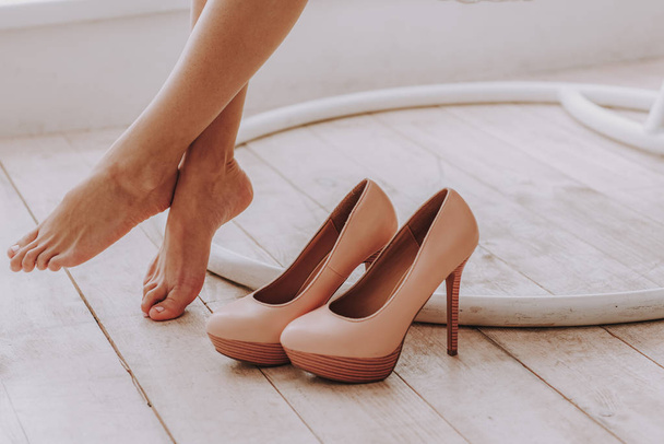 Businesswoman taking off high heels shoes after work at home - Fotoğraf, Görsel