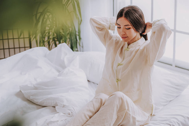 Calm pretty asian woman relaxing in cozy apartment - Фото, изображение