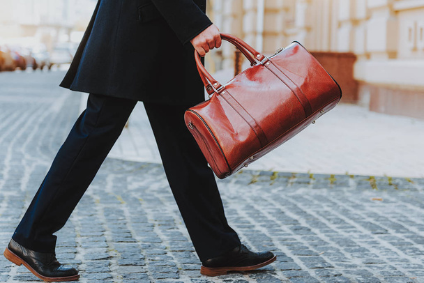 Elegant man is carrying leather bag outdoors - Fotografie, Obrázek