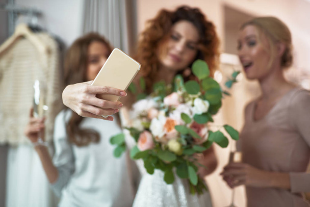 Young ladies making selfie in wedding salon - Фото, изображение