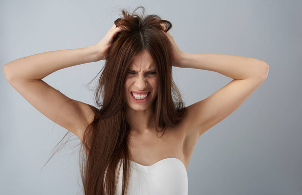 Upset young lady in white bra tearing her hair out - Foto, Imagem