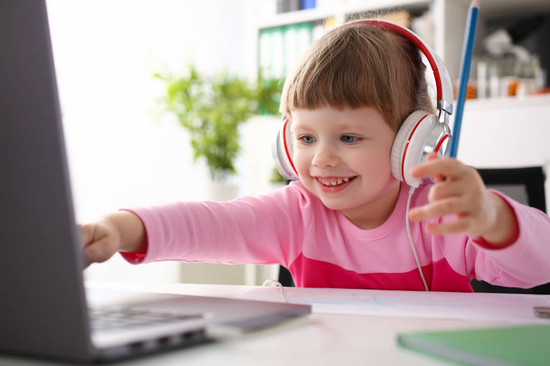Задоволена дитина в навушниках сидить
 - Фото, зображення