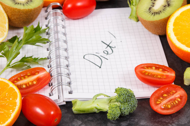 Φυσικά φρούτα με λαχανικά ως πηγή βιταμινών και σημειωματάριο με λέξη διατροφή, υγιεινό τρόπο ζωής και διατροφής έννοια - Φωτογραφία, εικόνα