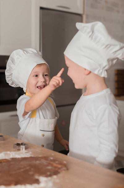 Happy Children in Caps and Apron Bake Cookies. Kitchen. Home Concept - Photo, Image