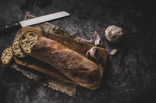 Fresh pastry baguette with herbs, garlic from home bakery - Фото, изображение