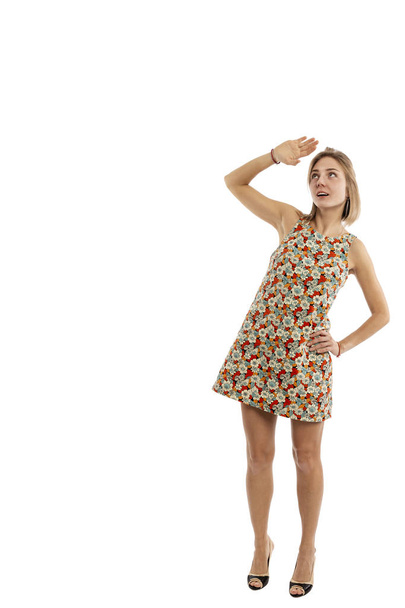 Young girl in a short dress in full growth looks up,  isolated on white background - Foto, immagini