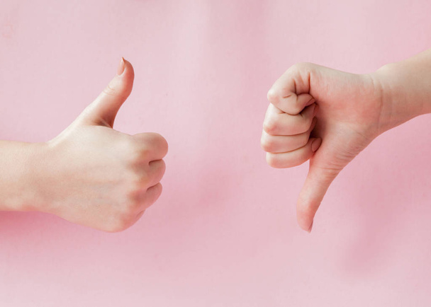 ピンクの背景、成功の概念、女性の手の親指を上昇傾向に光を手話のように, - 写真・画像