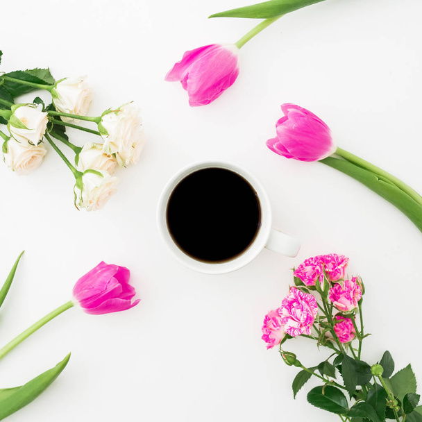 Komposition mit Tulpen, Rosen und Kaffeebecher auf weißem Hintergrund. flache Lage, Draufsicht. - Foto, Bild