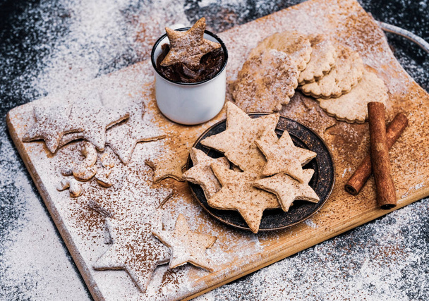 Star shaped christmas cookies decorated sugar and cocoa powder, a cup of hot chocolate. Close-up shot. - Fotó, kép
