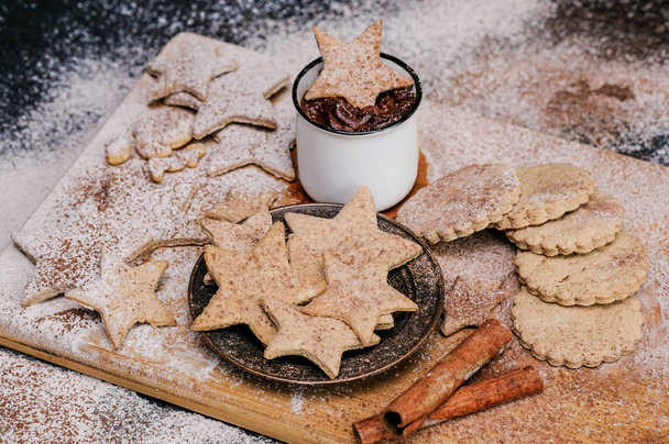 Star shaped christmas cookies decorated sugar and cocoa powder, a cup of hot chocolate. Close-up shot. - Foto, Imagem