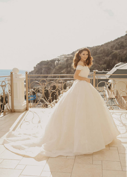 fashion interior photo of beautiful woman bride, with dark hair in luxurious wedding dress posing in elegant room - Фото, зображення