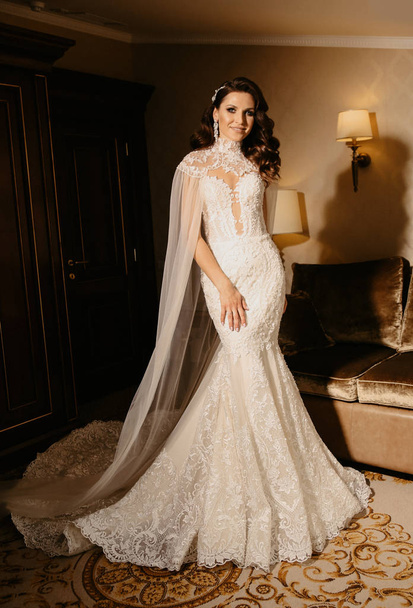 fashion interior photo of beautiful woman bride, with dark hair in luxurious wedding dress posing in elegant room - Фото, зображення
