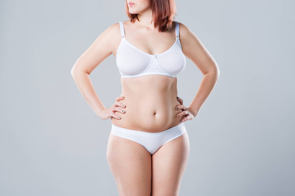 Woman with fat abdomen, overweight female body on gray background, studio shot - Fotoğraf, Görsel
