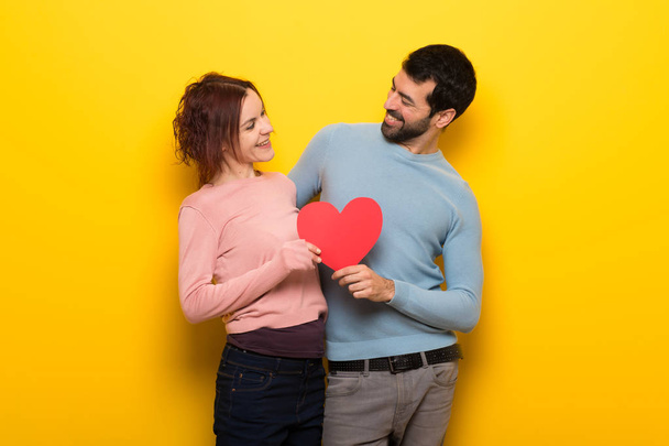 Couple in valentine day holding a heart symbol - Фото, зображення