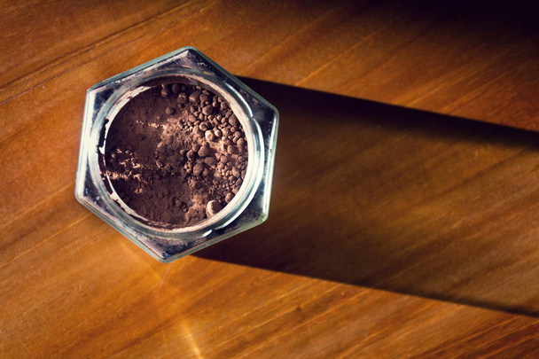 木製の茶色のテーブルは、フラット レイアウト ビュー、健康的な食事で横になっているガラスの瓶にココア パウダー - 写真・画像