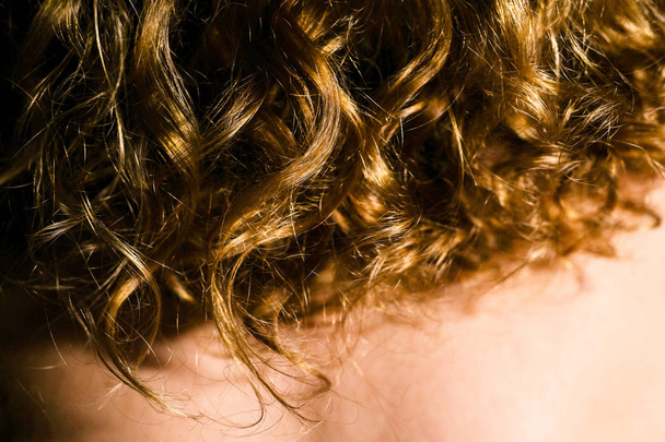 Natural curly red hair of a young woman, black background - Zdjęcie, obraz