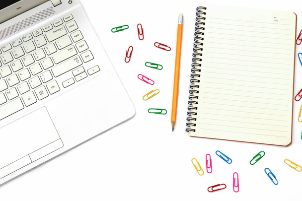 Компьютеры для ноутбуков, разноцветная скрепка для бумаги, блокнот с желтым карандашом на рабочем столе
 - Фото, изображение