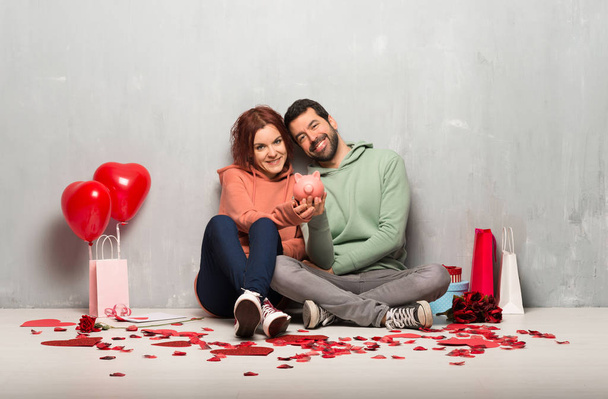 Couple in valentine day holding a piggybank - Foto, imagen
