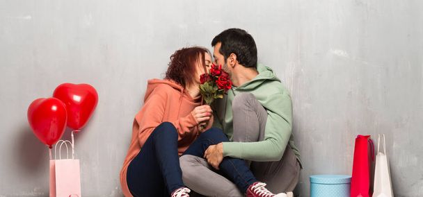 Ζευγάρι στην ημέρα του Αγίου Βαλεντίνου με λουλούδια και φιλιά - Φωτογραφία, εικόνα
