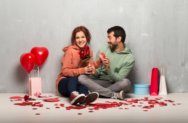 Ζευγάρι στην ημέρα του Αγίου Βαλεντίνου ημέρα αγκαλιάζει και με ένα τριαντάφυλλο - Φωτογραφία, εικόνα