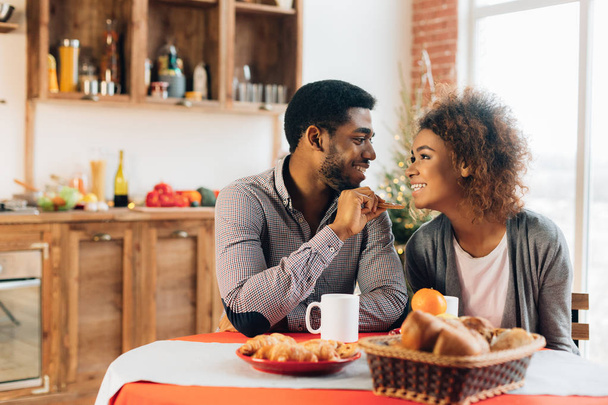 African-american couple enjoying tasty cookies in kitchen - Photo, Image