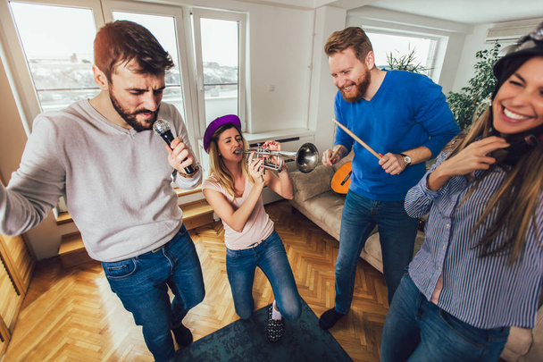 Evde karaoke yapan bir grup arkadaş. Arkadaşlık kavramı, ev eğlencesi ve insanlar - Fotoğraf, Görsel