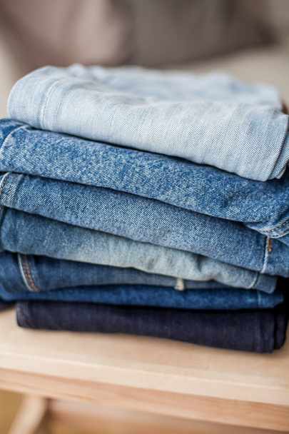 Jeans, denim katoen, blauw. Stack jeans in het interieur. Kleding. Gezellige. - Foto, afbeelding