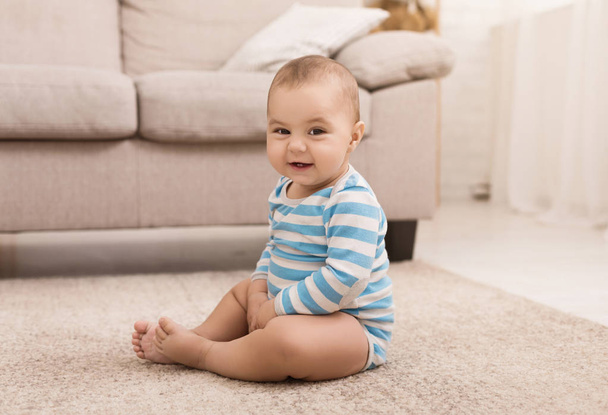 Cute baby boy sitting on floor at home - Foto, Imagem