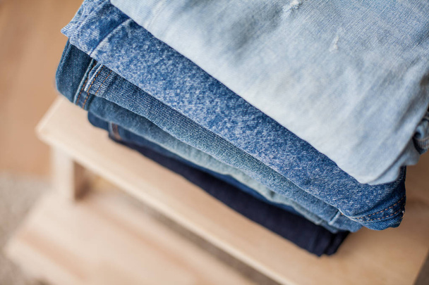 Jeans, Denim-Baumwolle, blau. Stapel Jeans im Innenraum. Kleidung. gemütlich. - Foto, Bild