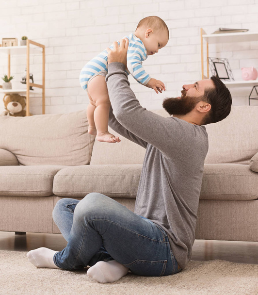 Hombre vomitando a su hijo en casa en la sala de estar
 - Foto, Imagen