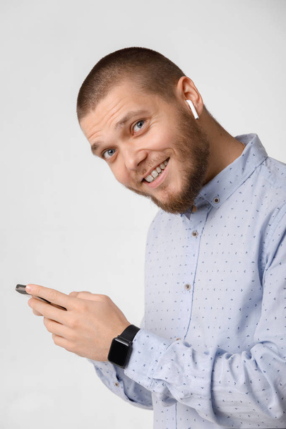 bearded businessman uses wireless headphones and smartphone - Photo, Image