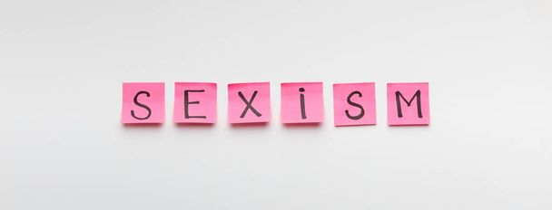 Palabra SEXISMO escrito en pegatinas de oficina de color rosa
 - Foto, imagen