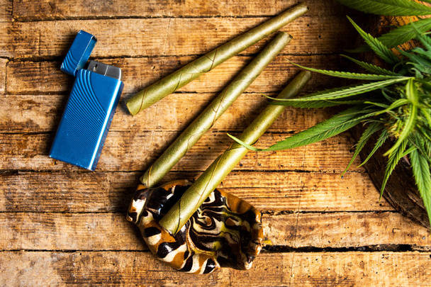 Marihuana-Pflanze mit Knospen und Joint auf Holztisch - Foto, Bild