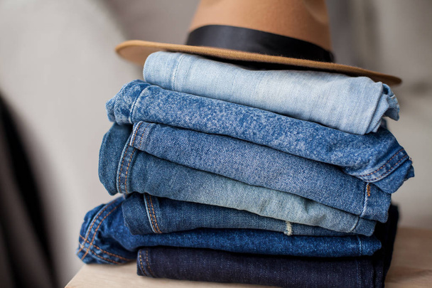 Jeans, felt hat, denim cotton, blue. Stack of jeans in the interior. Clothing.Cozy. - Foto, afbeelding