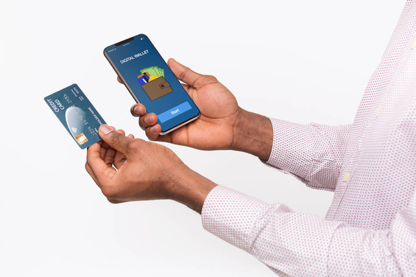 Mão segurando smartphone com carteira digital e cartão de crédito
 - Foto, Imagem