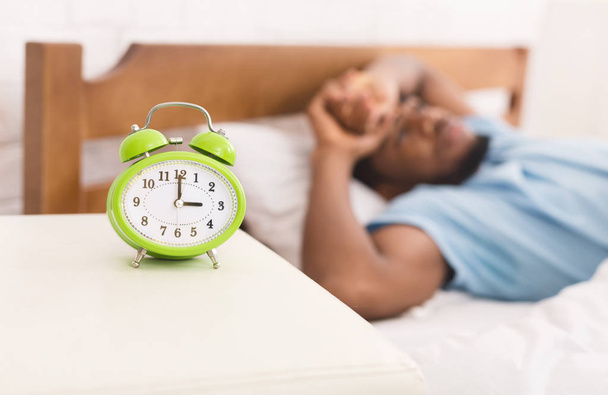 Hombre negro en la cama que sufre de insomnio y trastorno del sueño
 - Foto, imagen