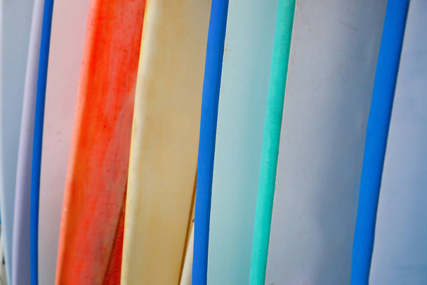 Stapel bunter Surfbretter zum Ausleihen am Strand - Foto, Bild