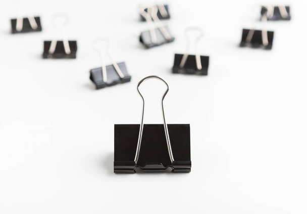 Big binder clip leading smaller ones on white background - Foto, immagini