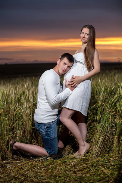 молодые родители вечером на пшеничном поле
 - Фото, изображение