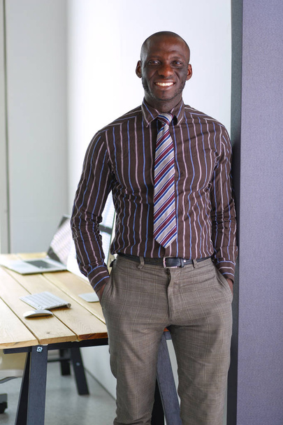 Portrait of an handsome black businessman standing in office - Foto, imagen
