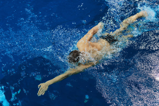 Mannelijke zwemmer bij het zwembad. Onderwaterfoto - Foto, afbeelding