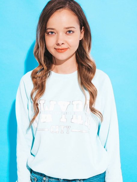 Portrait of of happy smiling girl with in casual clothes without makeup. Young woman model posing on blue background  - Fotografie, Obrázek