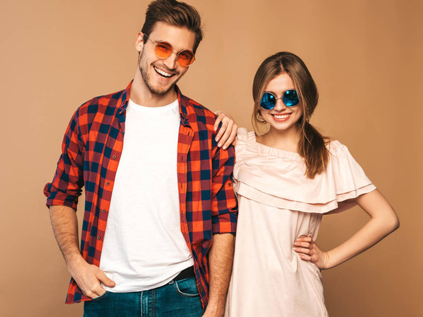 Portrait of Smiling Beautiful Girl and her Handsome Boyfriend laughing.Happy Cheerful Family. in sunglasses.Valentine's Day. Posing on beige wall. Hugging - Φωτογραφία, εικόνα