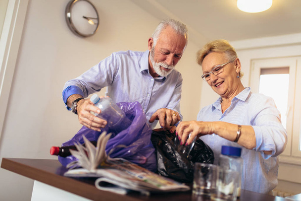 Senior couple separating recyclable trash at home - Fotoğraf, Görsel