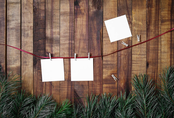 Lege fotopapier hechten aan touw met wasknijpers op houten tafel achtergrond. Plat leggen. - Foto, afbeelding