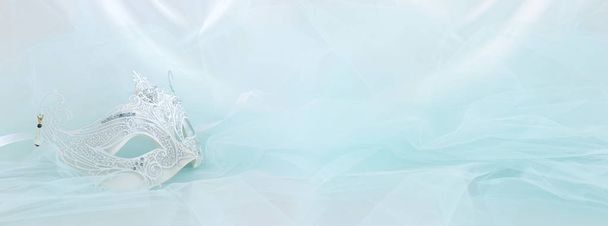 Banner of elegant and delicate white lace venetian mask over mint chiffon background - Photo, image