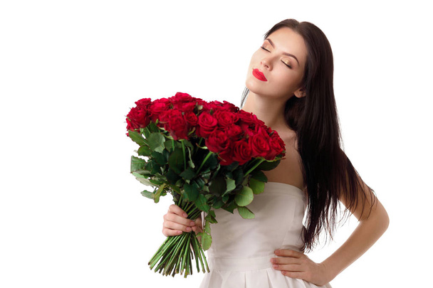 beautiful young woman with a large bouquet of red roses - Fotó, kép
